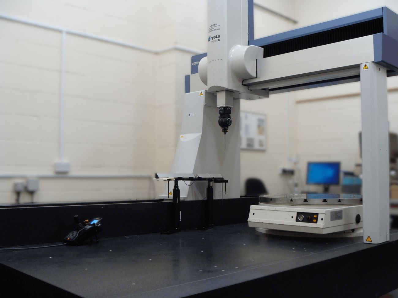 Bridge-type coordinate measuring machine on a granite table in an inspection lab